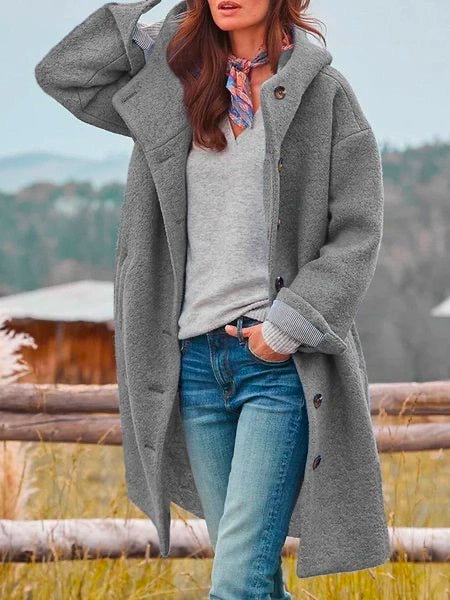 Frau in grauem Wollmantel, Jeans, Schal, Herbstlandschaft, modisch, warm, stilvoll.