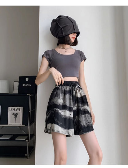 Frau in grauem Crop-Top und schwarz-weißem Rock, modisch, modern, stilvoll, Innenraum.