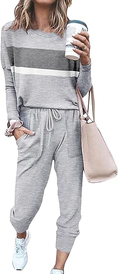 Frau in grauem Jogginganzug mit Streifen, hält Kaffeebecher und beigefarbene Tasche.