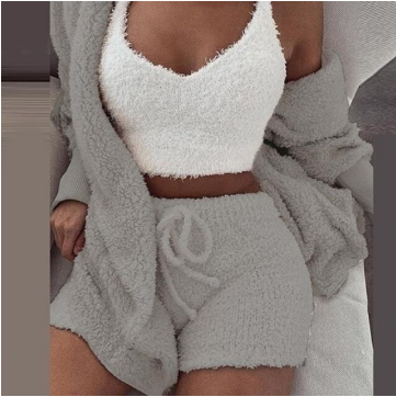 Frau in grauem Fleece-Set mit Shorts und weißem Top, gemütliche Loungewear, modisch, bequem.