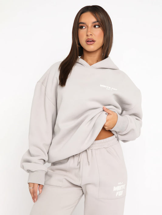 Frau in grauem Hoodie und Jogginghose, lässige Mode, bequeme Freizeitkleidung, Streetwear.