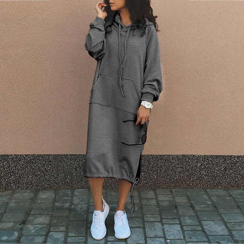 Frau in grauem Kapuzenkleid mit Taschen, lässig, modisch, Herbstmode, weiße Sneaker.