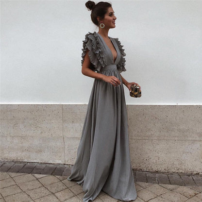 Frau in grauem Abendkleid mit Rüschen, elegantes Design, modisches Outfit, festliche Kleidung.