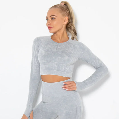 Frau in grauem nahtlosem Sport-Set, Langarm-Top und Leggings, Fitnessmode, Sportbekleidung.