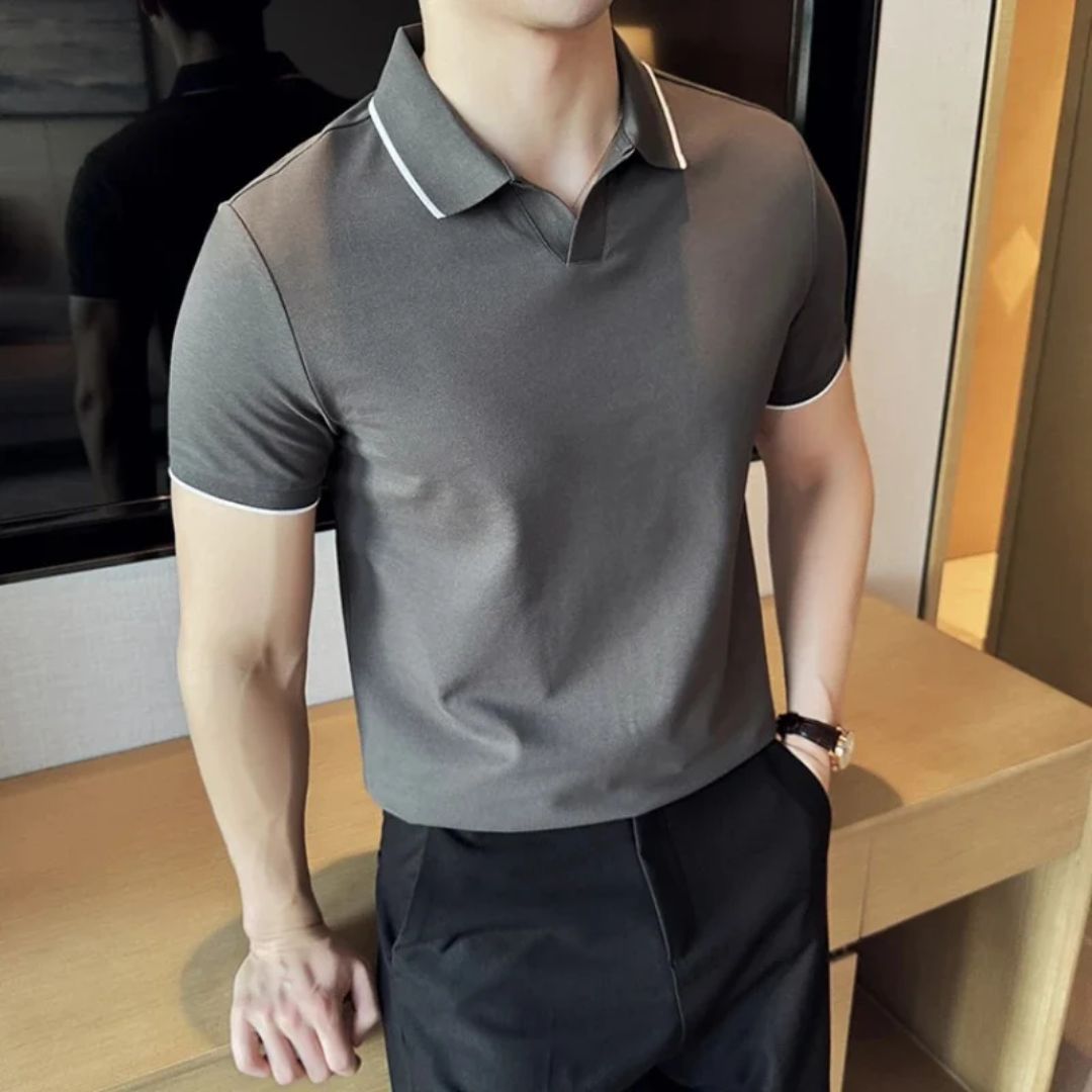 Mann in grauem Polohemd, schwarze Hose, moderne Herrenmode, eleganter Freizeitlook.