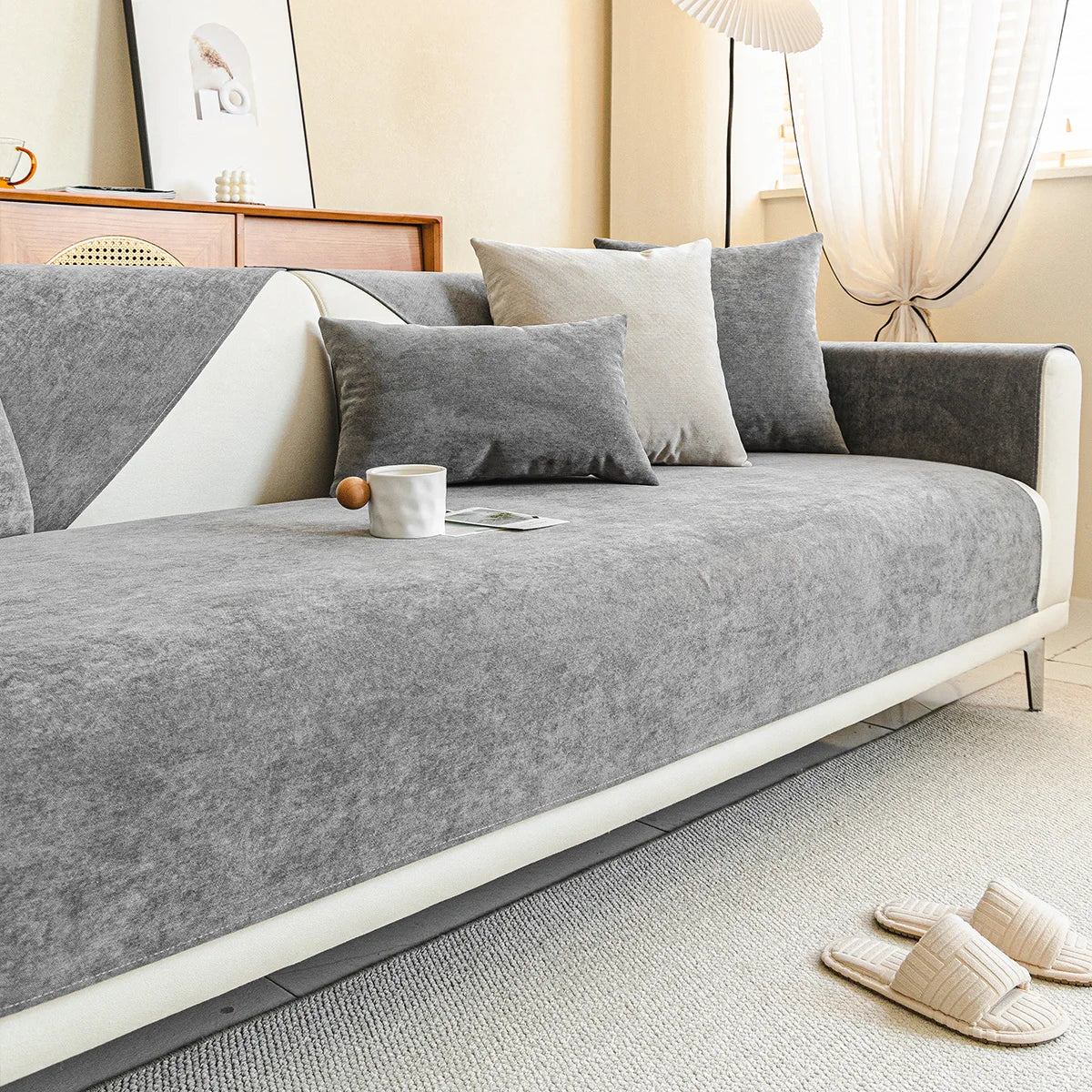 Graues Samtsofa mit Kissen, modernes Wohnzimmer, gemütliche Einrichtung, skandinavischer Stil.