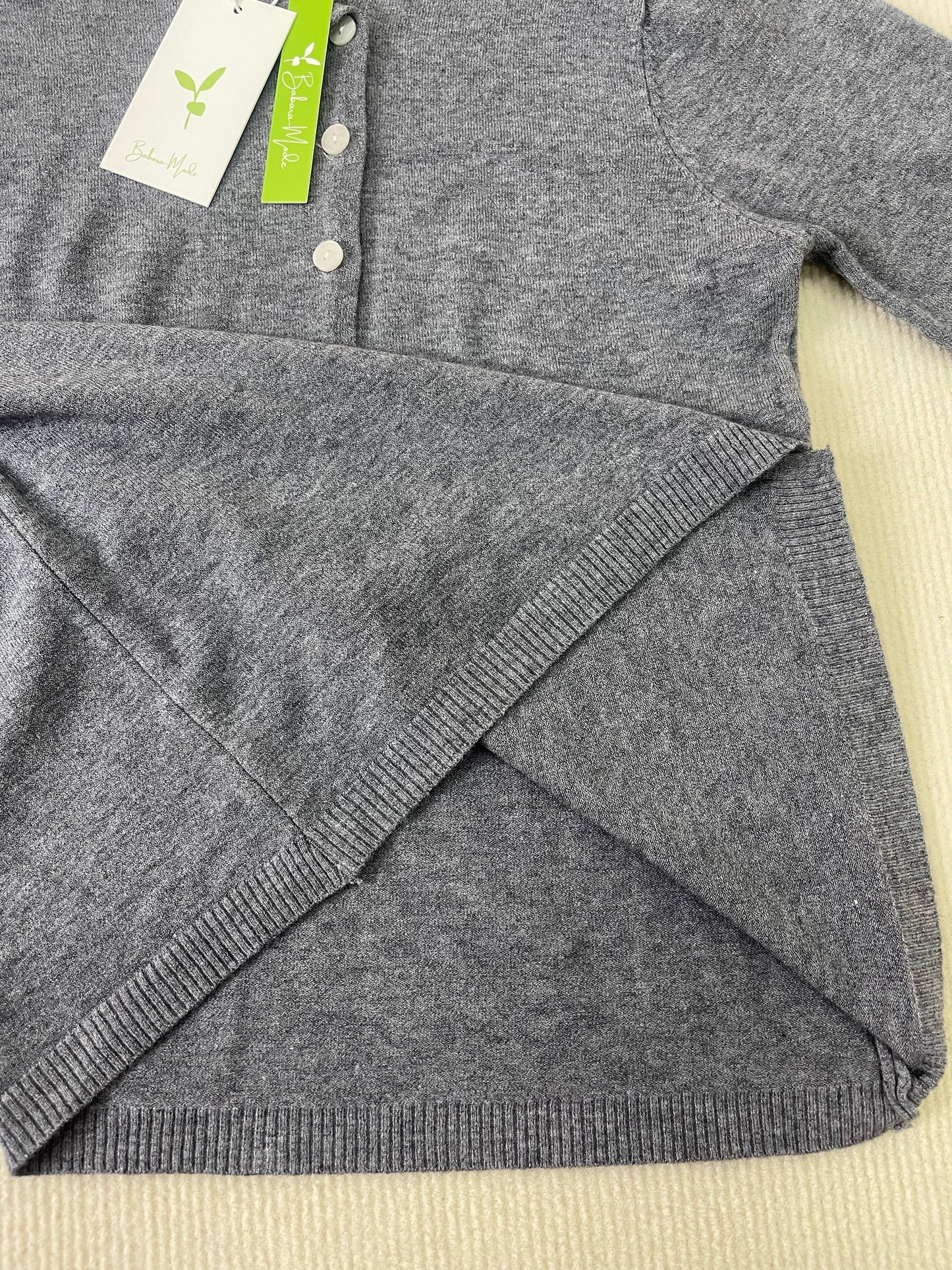Grauer Strickpullover aus Bio-Baumwolle, Knopfleiste, nachhaltige Mode, weiches Material.