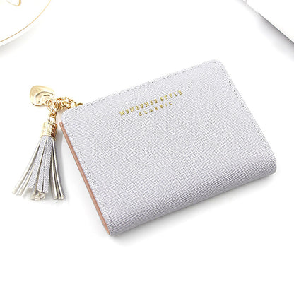 Graues Damenportemonnaie aus Leder mit Quaste und goldenen Akzenten, elegant und stilvoll.