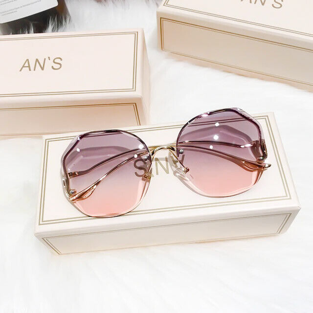 Rosa-graue Sonnenbrille mit geometrischem Design auf weißer Box, modisch, Damenaccessoire.