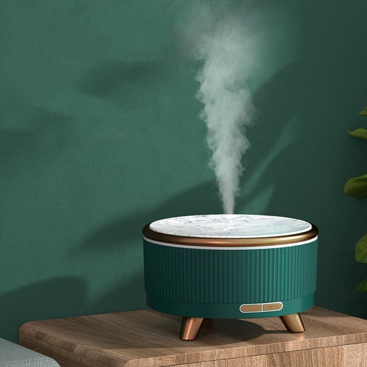 Grüner Aromatherapie-Luftbefeuchter auf Holztisch, moderner Stil, Dampf aus Marmoroberfläche.