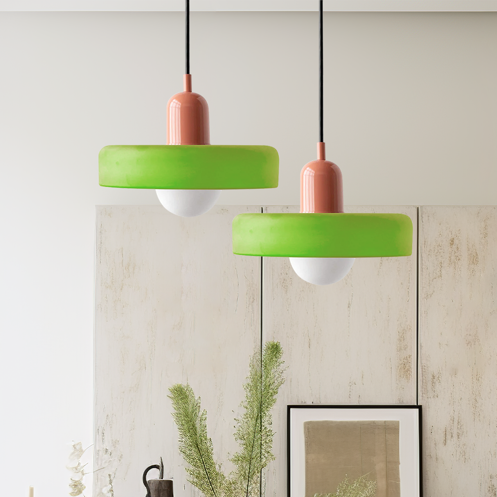 Zwei grüne Pendelleuchten mit rotem Sockel, modernes Design, Innenbeleuchtung.
