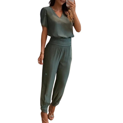Frau in grünem Jumpsuit, V-Ausschnitt, kurze Ärmel, elegantes Design, Sommermode.