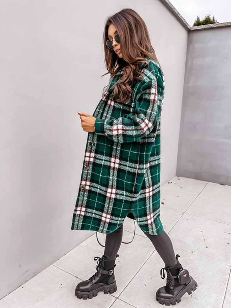 Schwangere Frau in grün-kariertem Mantel, schwarze Stiefel, moderne Umstandsmode, Herbstlook.