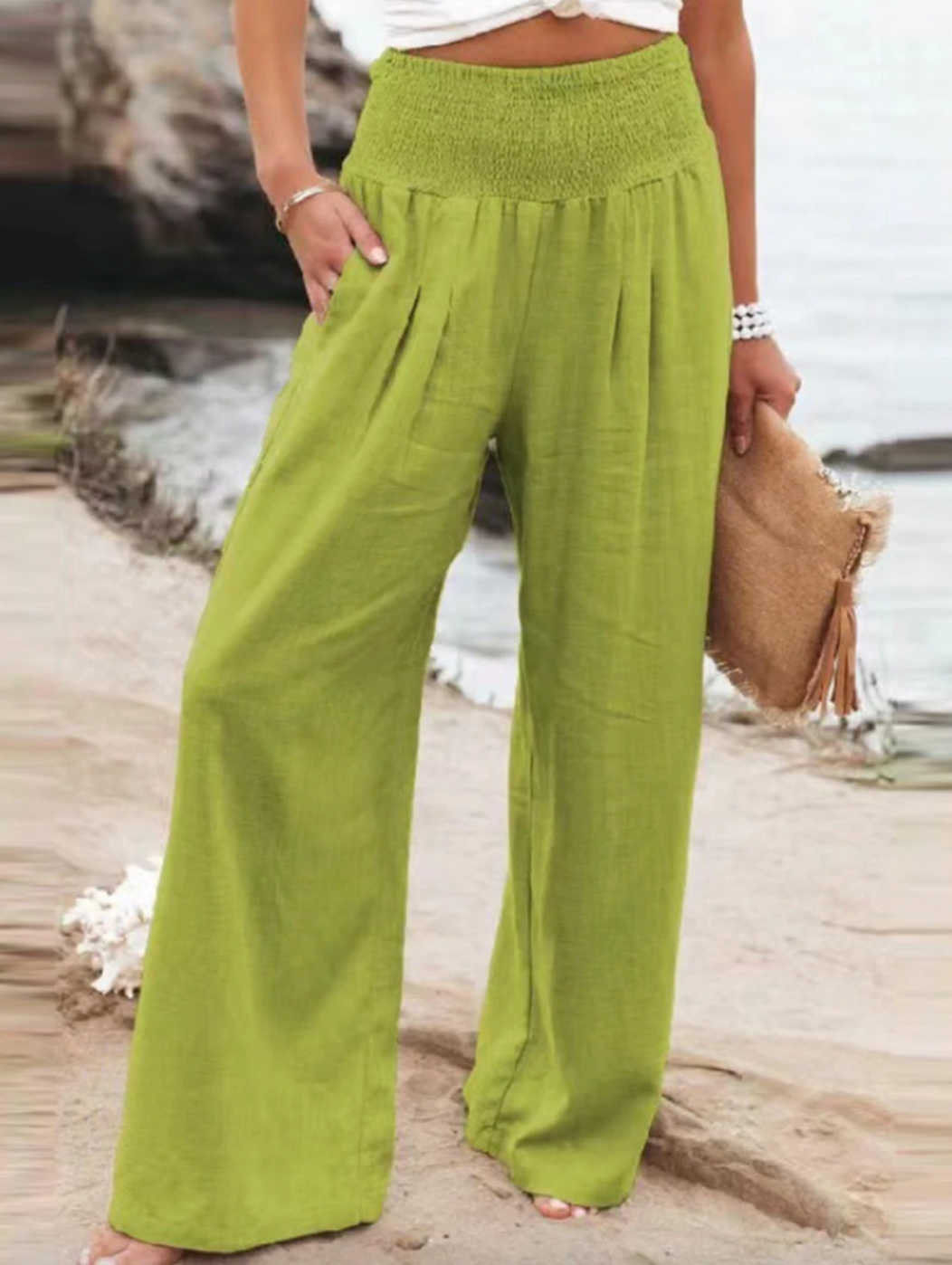 Frau in grüner Leinenhose am Strand, Sommermode, lässiger Stil, Strandtasche.