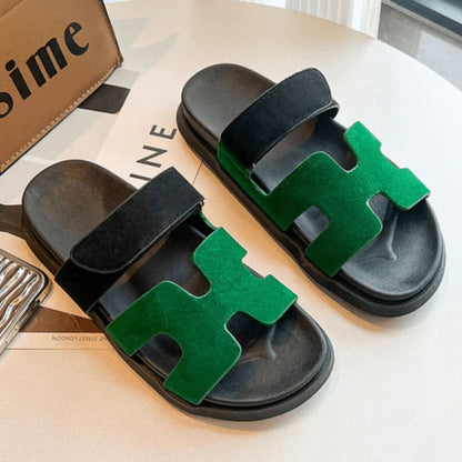 Grüne und schwarze Sandalen mit Klettverschluss auf Tisch, modische Sommerschuhe.