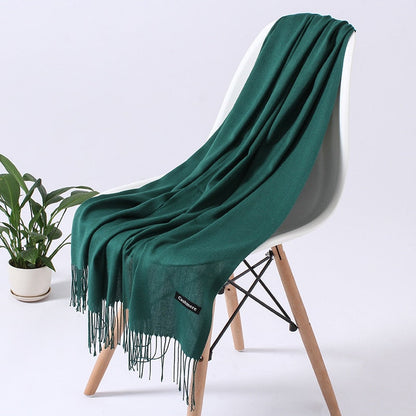 Grüner Kaschmirschal auf weißem Stuhl, weiches Material, modisches Accessoire, Wohnzimmerdeko.