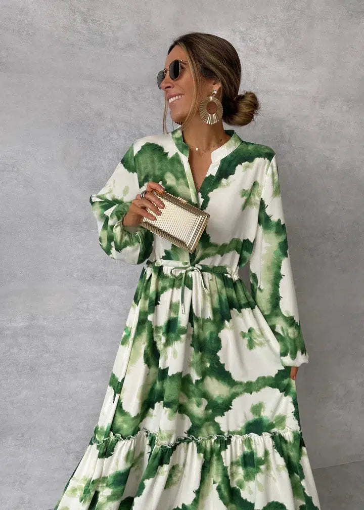Frau im grünen und weißen Kleid mit Sonnenbrille und Clutch, modische Damenbekleidung.