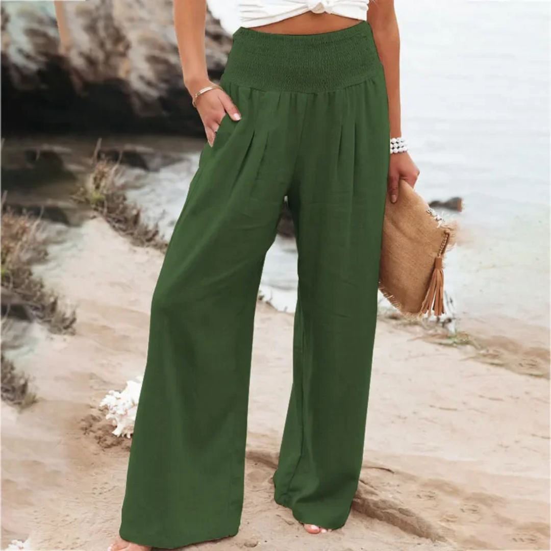 Frau in grüner Leinenhose am Strand, Sommermode, Damenbekleidung, lässiger Stil.