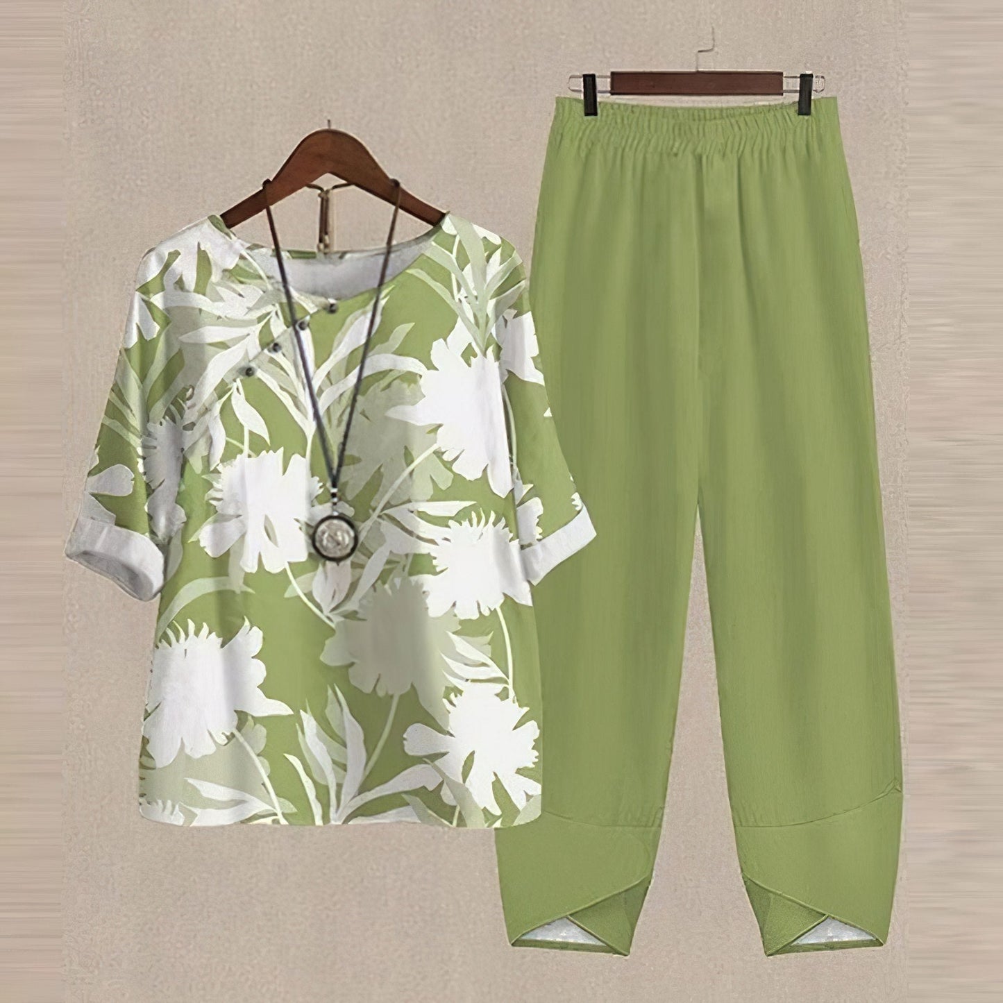 Grünes Damen-Outfit mit Blumenmuster, bestehend aus Bluse und Hose, lässig und modisch.