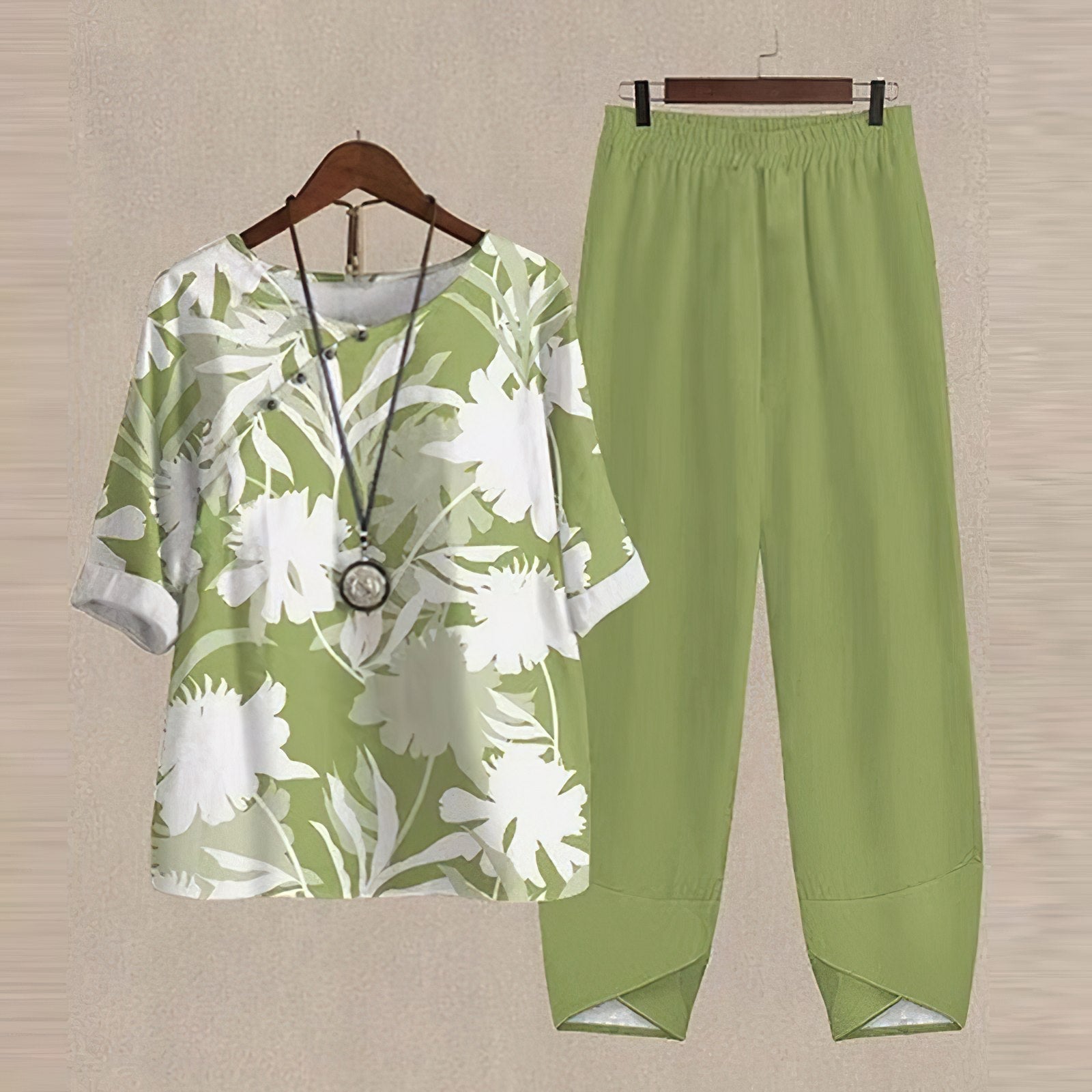 Grünes Damen-Outfit mit Blumenmuster, bestehend aus Bluse und Hose, lässig und modisch.