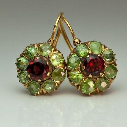 Goldene Ohrringe mit grünen und roten Edelsteinen, Vintage-Stil, eleganter Schmuck.