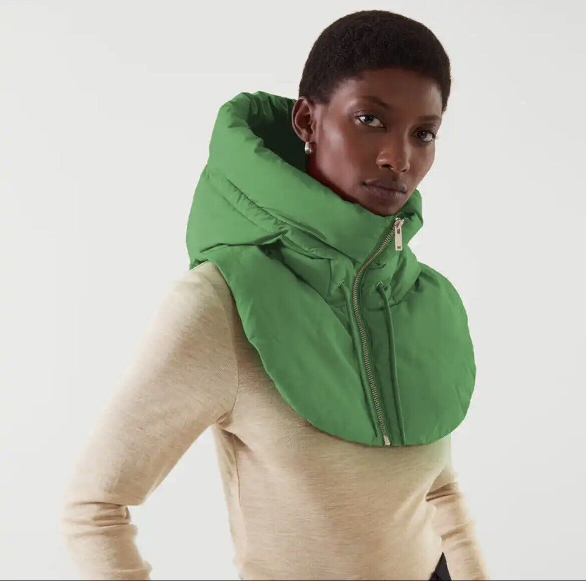 Frau trägt grünen Kapuzenschal, Reißverschluss, modisch, warm, Winteraccessoire, Damenmode.