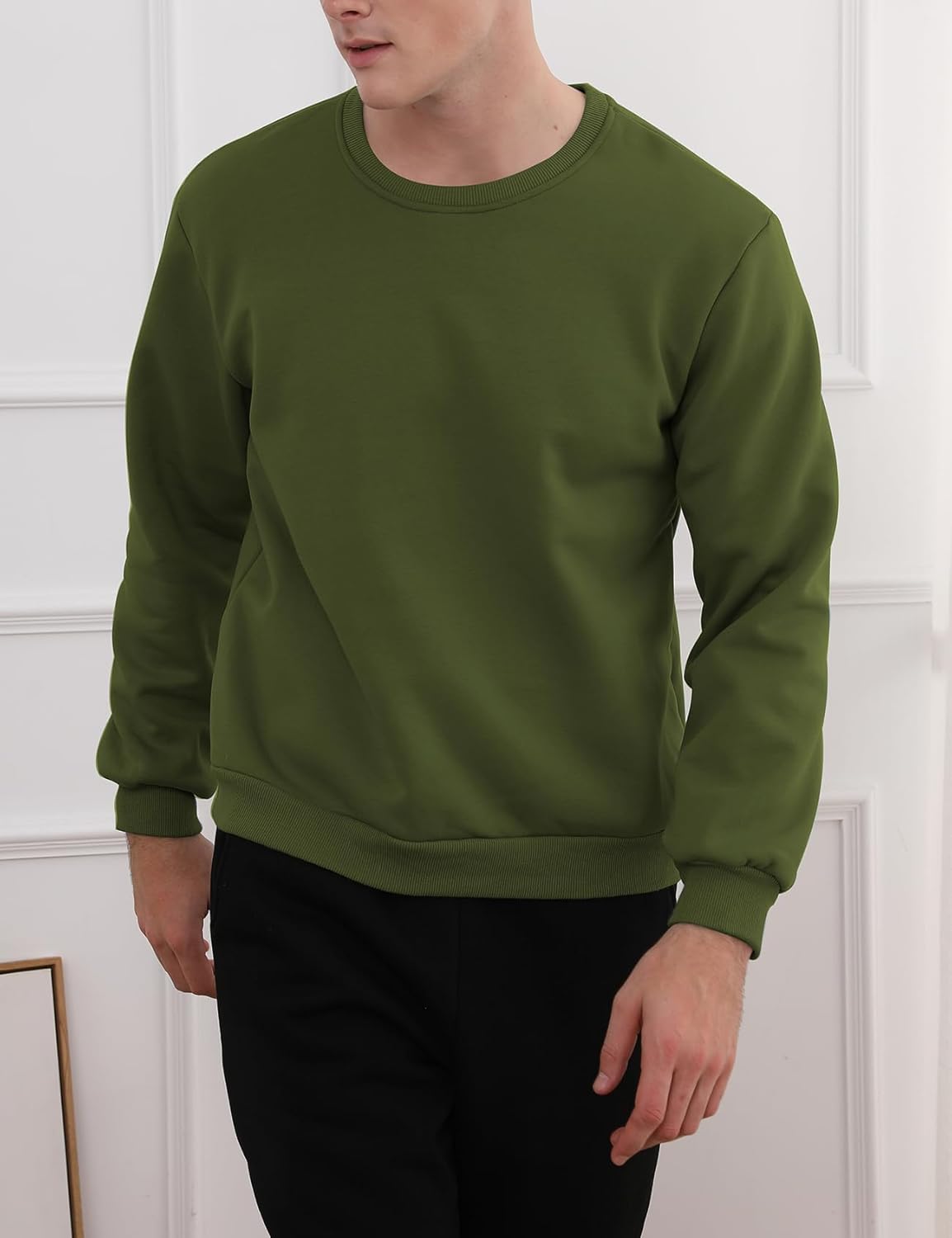 Mann trägt grünen Pullover, Rundhalsausschnitt, Freizeitmode, Herrenbekleidung, Baumwolle.