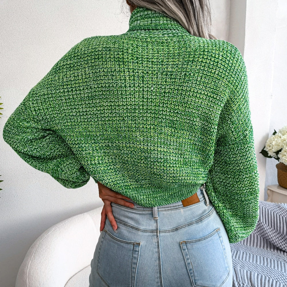 Frau in grünem Strickpullover und blauer Jeans, Rückansicht, modisch, gemütlich.