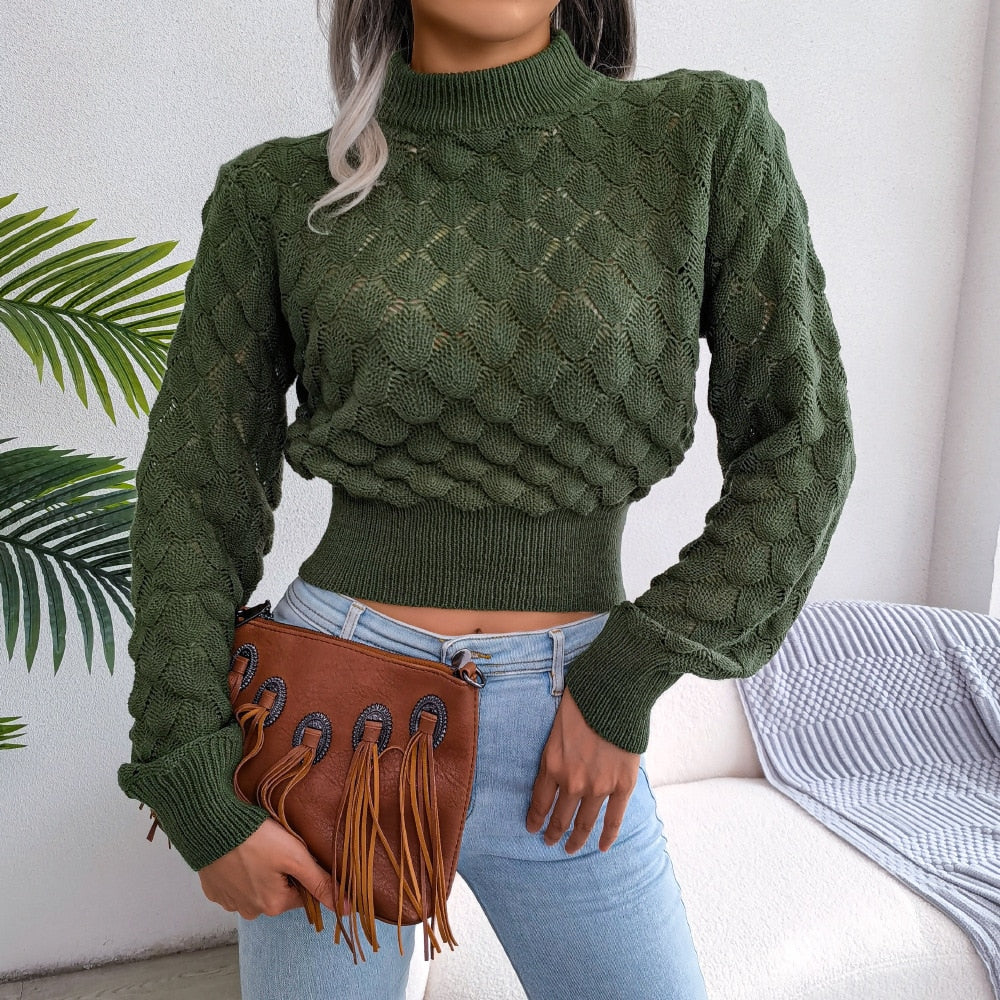 Frau in grünem Strickpullover, blaue Jeans, braune Fransenhandtasche, moderne Mode.