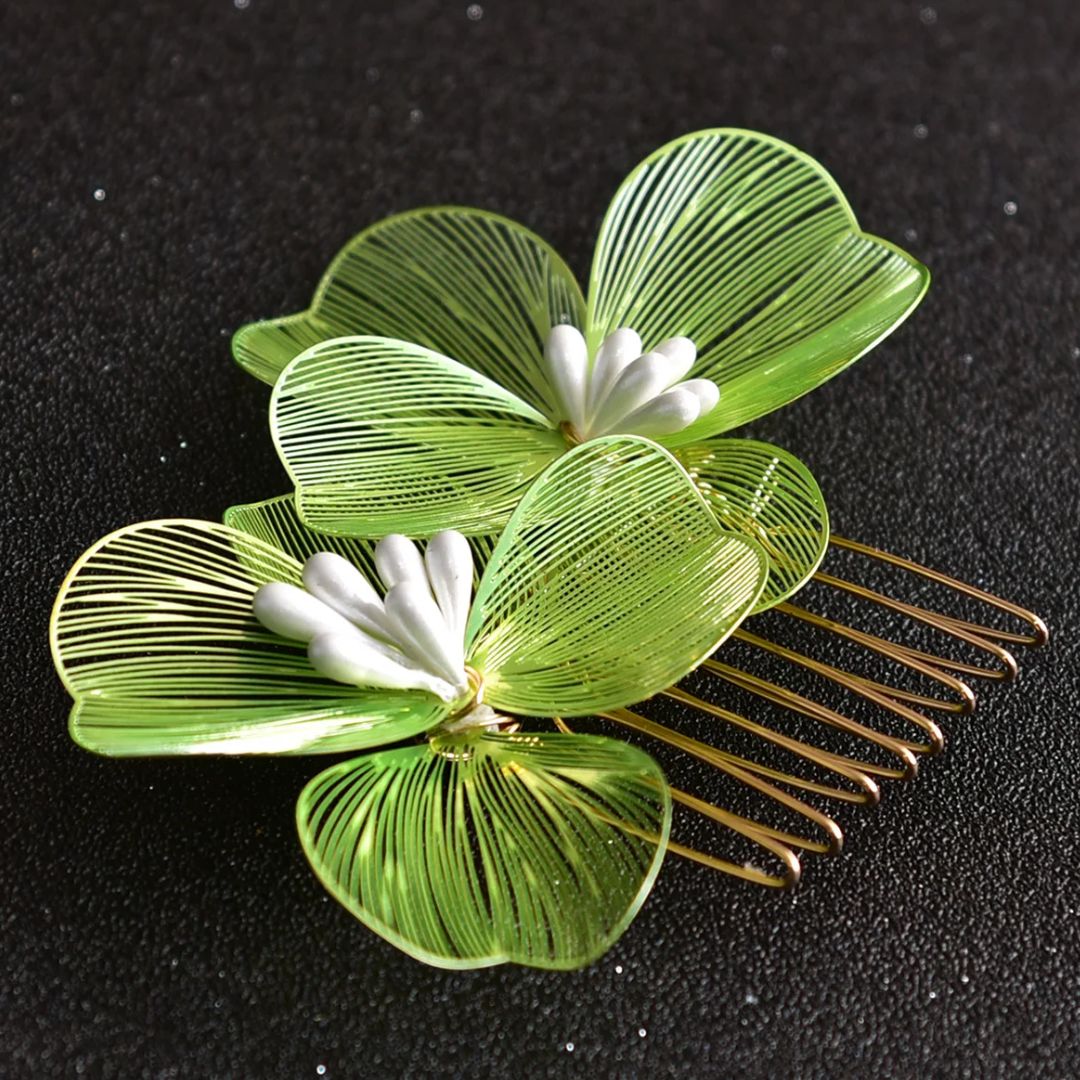 Grüner Haarkamm mit Blumenmotiv, goldene Zinken, elegantes Accessoire für Damenfrisuren.