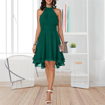 Frau in grünem Cocktailkleid, ärmellos, knielang, elegantes Design, weiße Sandalen.