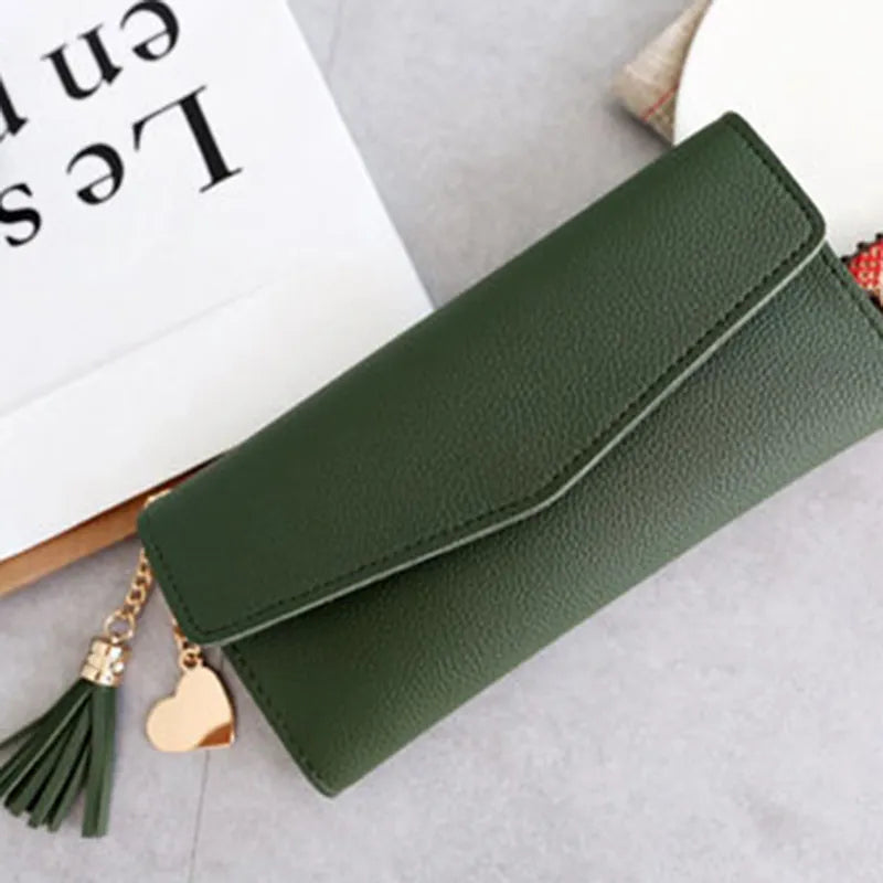 Grüne Damen-Geldbörse aus Leder mit Herzanhänger und Quaste, elegant und stilvoll.