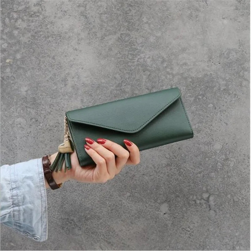 Grüne Damen-Geldbörse aus Leder mit Quastenanhänger, elegant und modern.