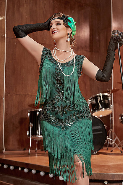 Frau im grünen Fransen-Kleid, 1920er Jahre Stil, mit Perlenkette, auf Bühne mit Schlagzeug.