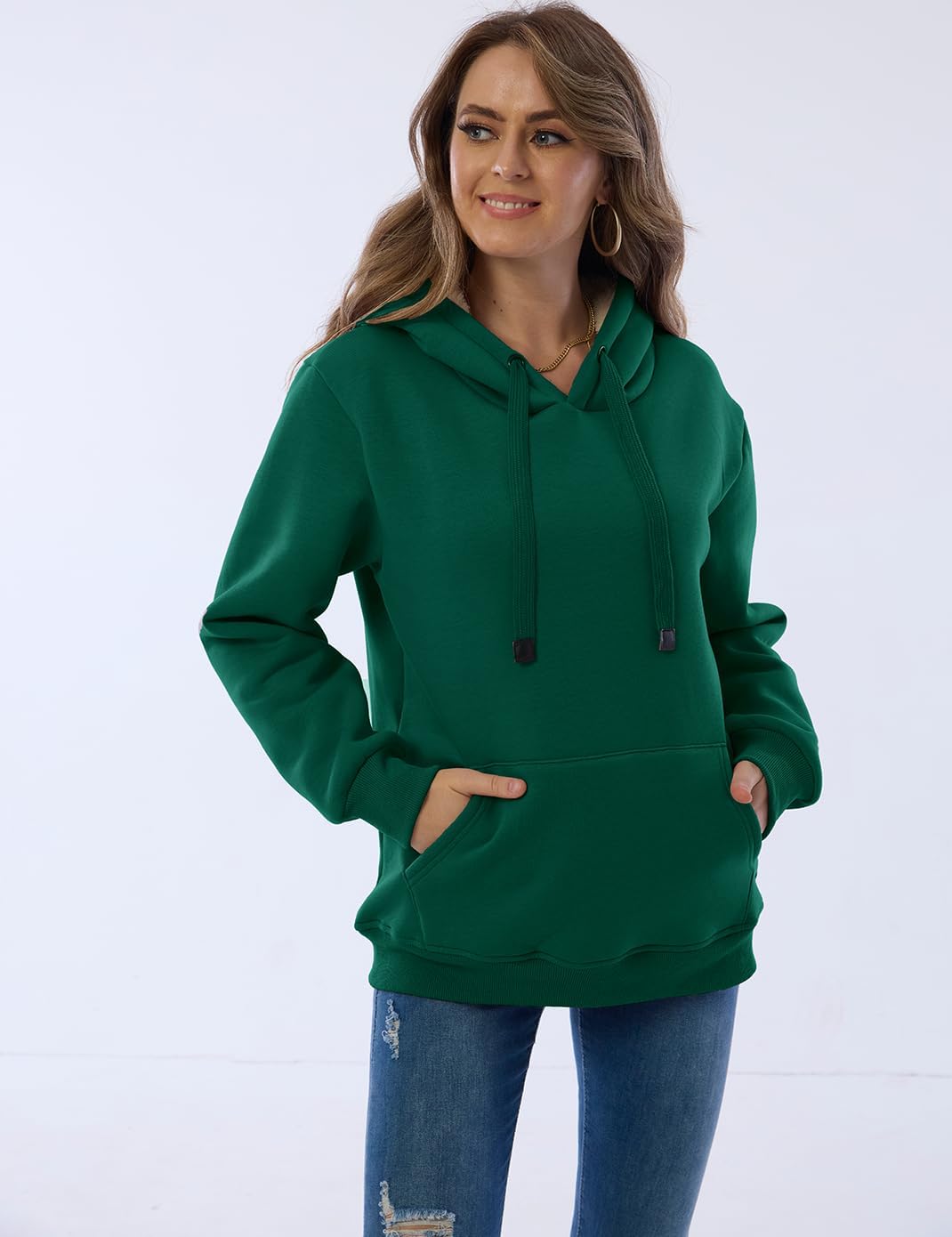 Frau in grünem Kapuzenpullover, lässig, bequem, Damenmode, Freizeitkleidung, Jeans.