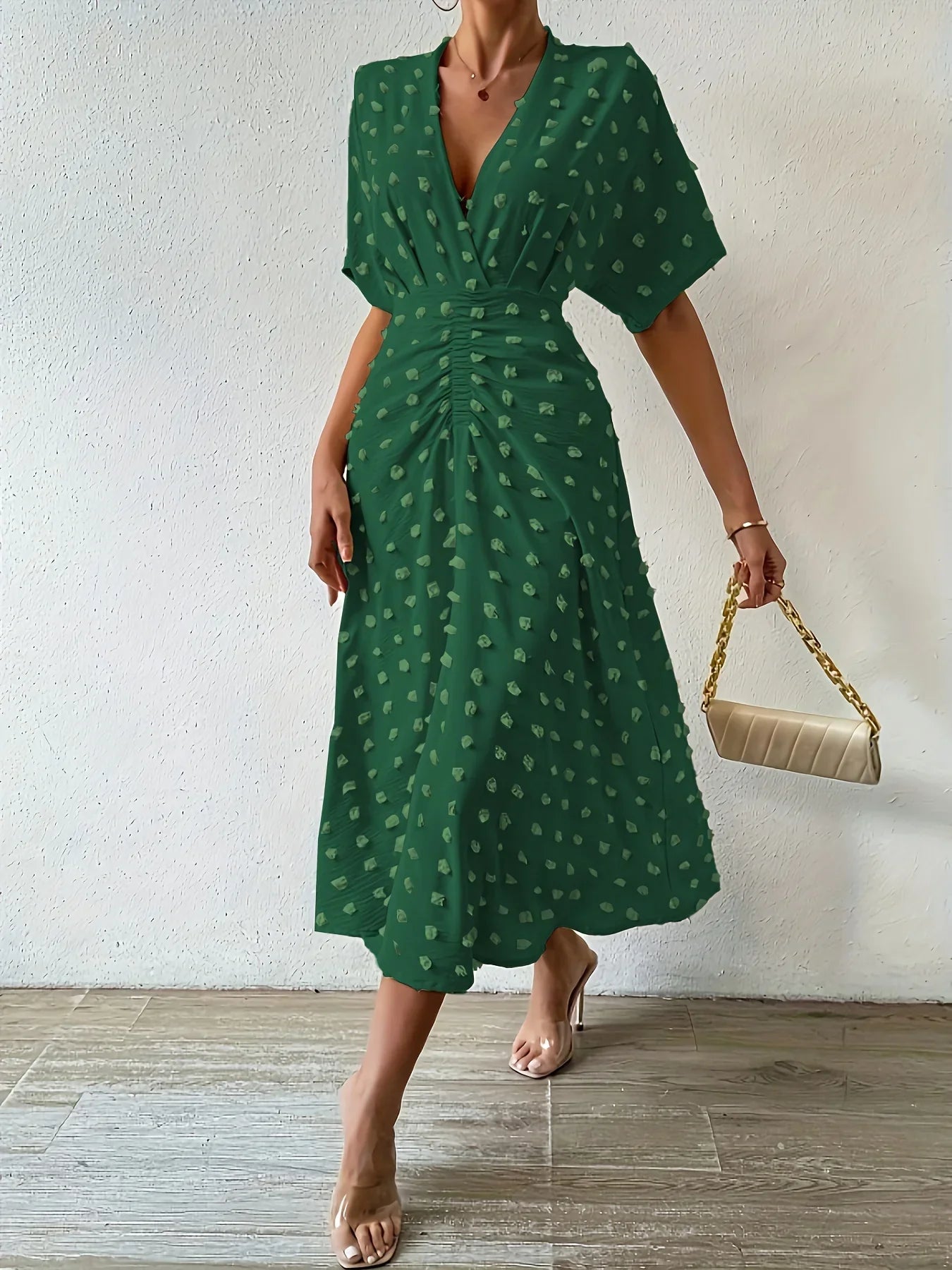 Grünes Damenkleid mit V-Ausschnitt, gepunktet, knielang, elegant, Sommermode.