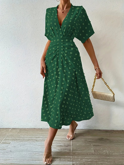 Grünes Damenkleid mit V-Ausschnitt, gepunktet, knielang, elegant, Sommermode.