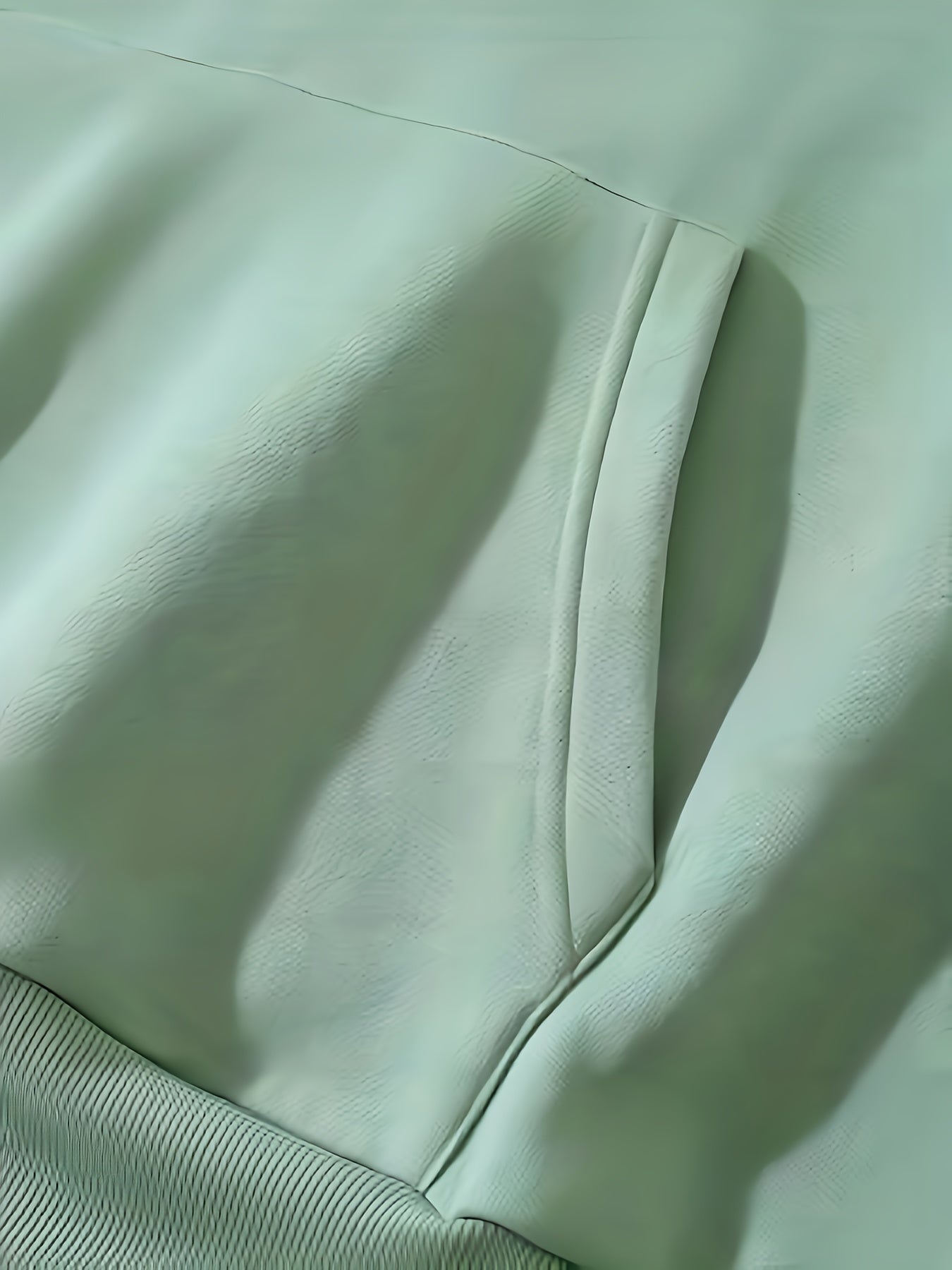 Grüne Lederjacke Detailansicht, weiches Material, modisches Design, hochwertige Verarbeitung.