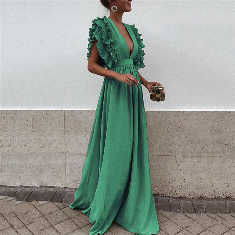 Frau in langem, grünem Abendkleid mit Rüschenärmeln, elegantes Design, modisches Outfit.