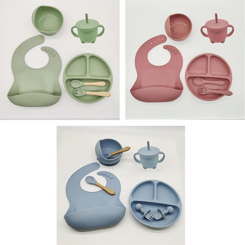 Dreiteiliges Silikon-Babytischset in Grün, Rosa und Blau mit Lätzchen, Teller und Besteck.