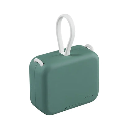 Grüne tragbare Powerbank mit weißem Tragegriff, kompakt, ideal für unterwegs.