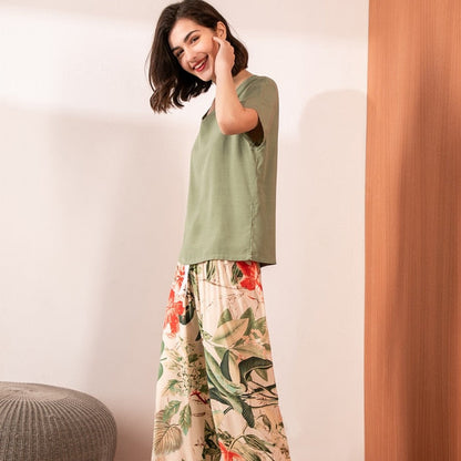 Frau in grünem T-Shirt und geblümter Hose, lächelnd, modisch, lässig, Sommerkleidung.
