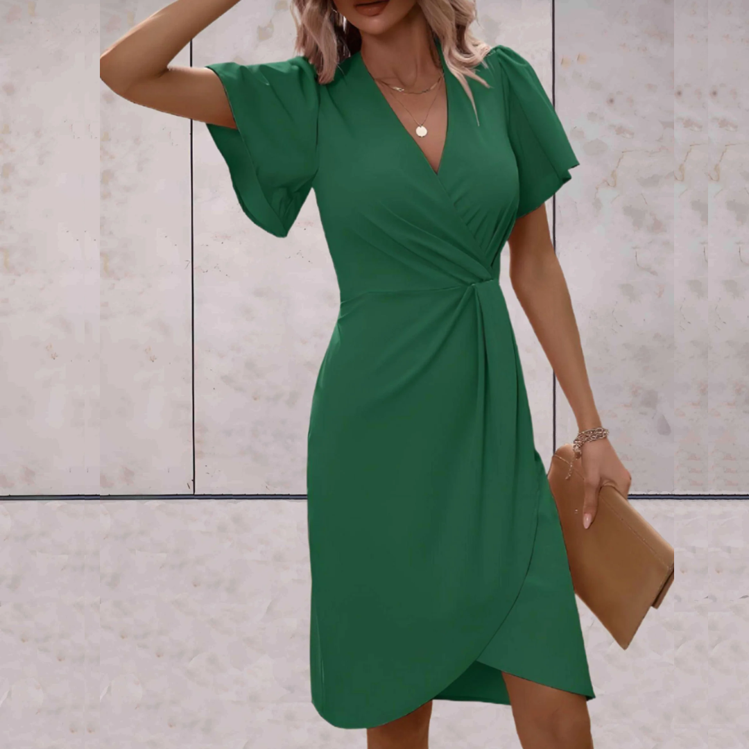 Frau in grünem Wickelkleid, elegantes Design, Sommermode, mit beiger Clutch.