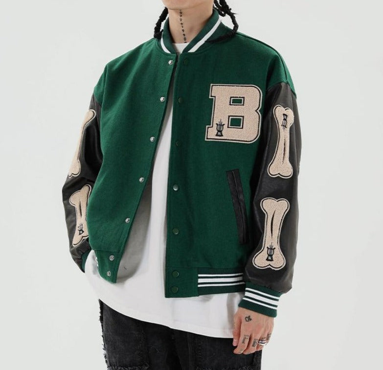 Grüne Collegejacke mit Lederärmeln, Buchstaben- und Knochenapplikationen, Unisex-Mode.