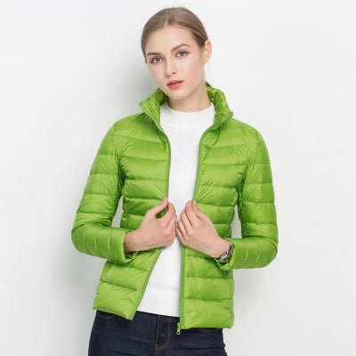 Frau in grüner Daunenjacke, Stehkragen, Reißverschluss, modisch, warm, Winterbekleidung.