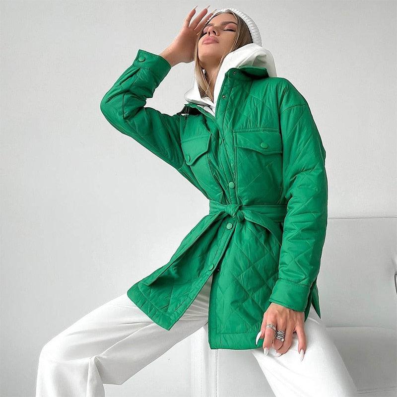 Frau in grüner Steppjacke mit Gürtel, weißer Kapuze, modisch, elegant, Herbstmode.