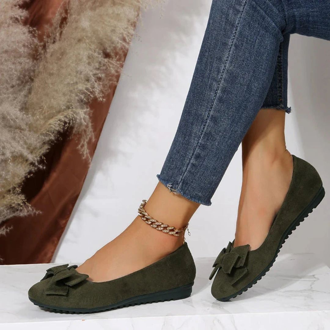 Damen Ballerinas aus grünem Wildleder mit Schleife, kombiniert mit blauen Jeans.