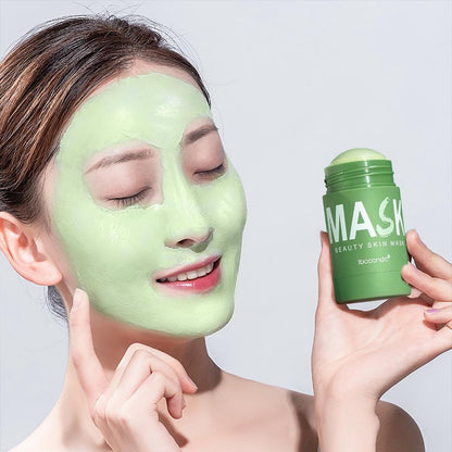 Frau mit grüner Gesichtsmaske, hält grünen Maskenstift, Hautpflege, Beauty-Produkt.