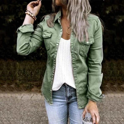 Frau in grüner Jeansjacke, weißem Stricktop, blauer Jeans, lässige Mode, Outdoor-Hintergrund.