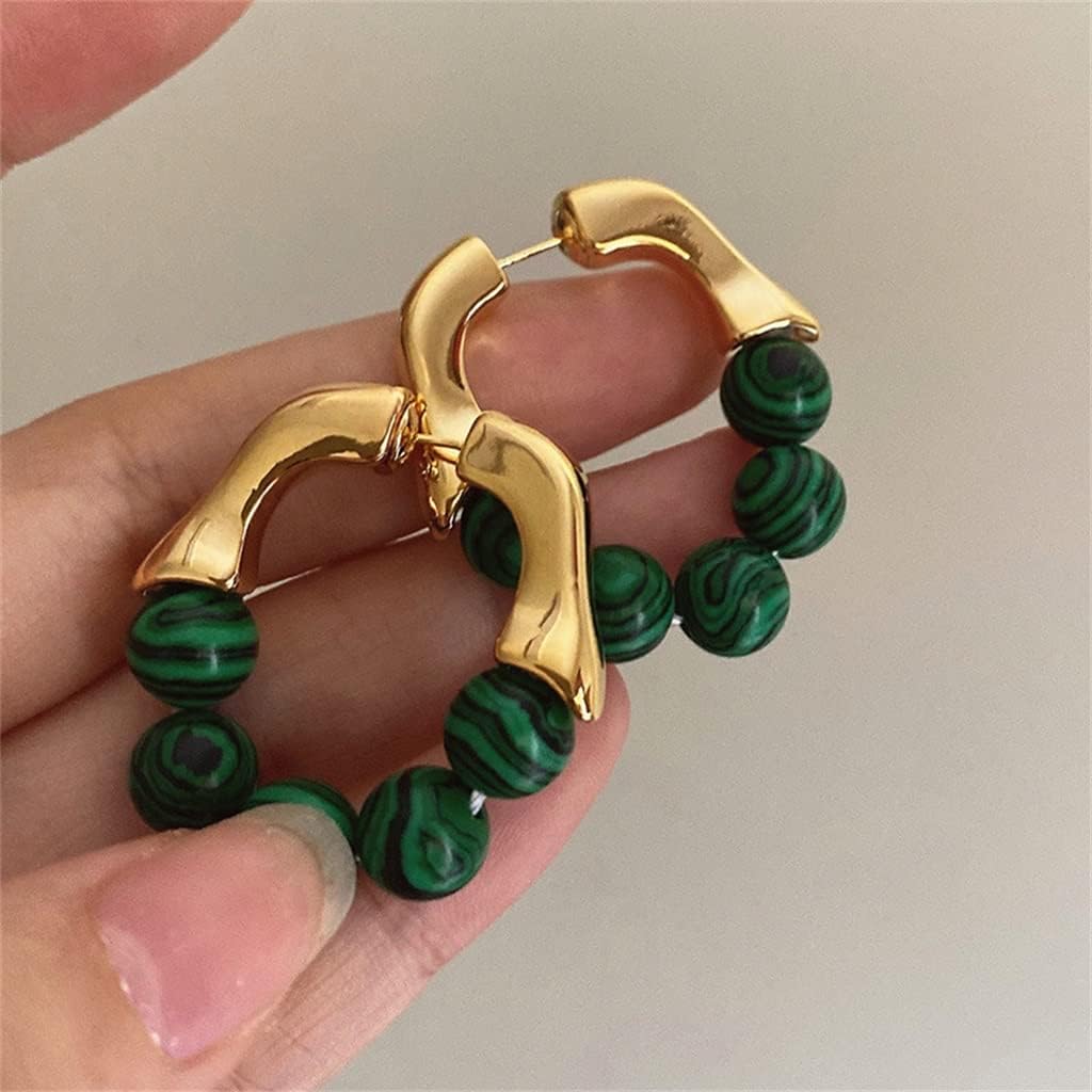 Goldene Ohrringe mit grünen Malachit-Perlen, modisches Schmuckdesign, handgehalten.